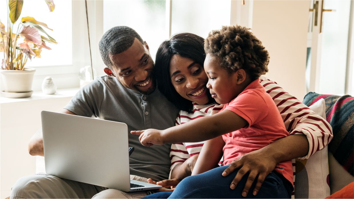 image of a happy black family looking at a laptop screen